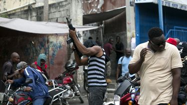 Un oficial de policía fuera de servicio dispara sus armas al aire durante una protesta por el salario y las condiciones de trabajo de las fuerzas del orden en Haití.