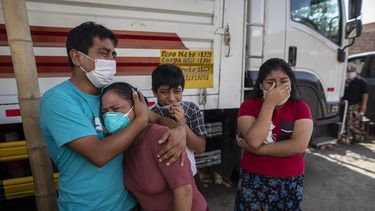 Familiares lloran mientras observan como operarios de la funeraria Piedrangel retiran el cuerpo de un pariente que se cree que murió a causa del nuevo coronavirus, en Lima, Perú, el 11 de mayo de 2020. Pese a las estrictas medidas para controlar el virus, Perú es uno de los países más afectados por la pandemia.