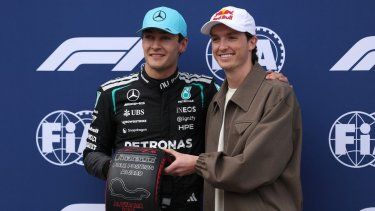 El piloto británico de Mercedes, George Russell (izq.), recibe su premio Pirelli Pole Position de manos del snowboarder australiano Scotty James en el escenario después de clasificar para el Gran Premio de Australia de Fórmula Uno en el Circuito Albert Park en Melbourne el 7 de marzo de 2026.&nbsp;