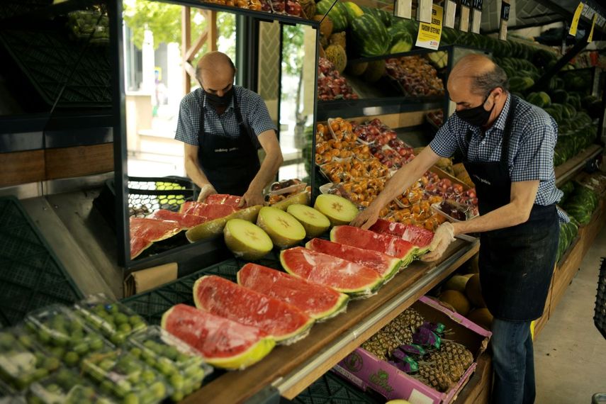 Un trabajador dispone fruta para la venta en un mercado. &nbsp;