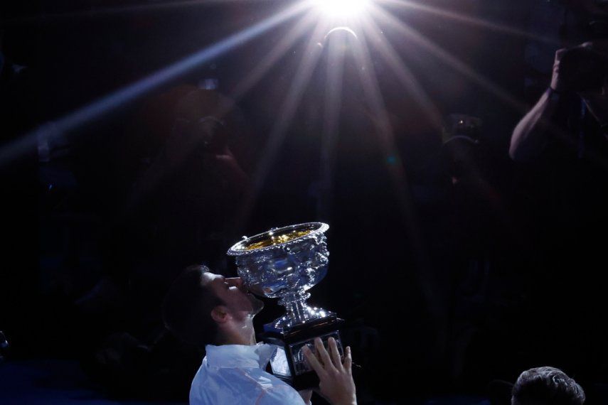 Novak Djokovic besa el trofeo de campeón del Abierto de Australia tras derrotar a Stefanos Tsitsipas en la final, el domingo 29 de enero de 2023, en Melbourne.