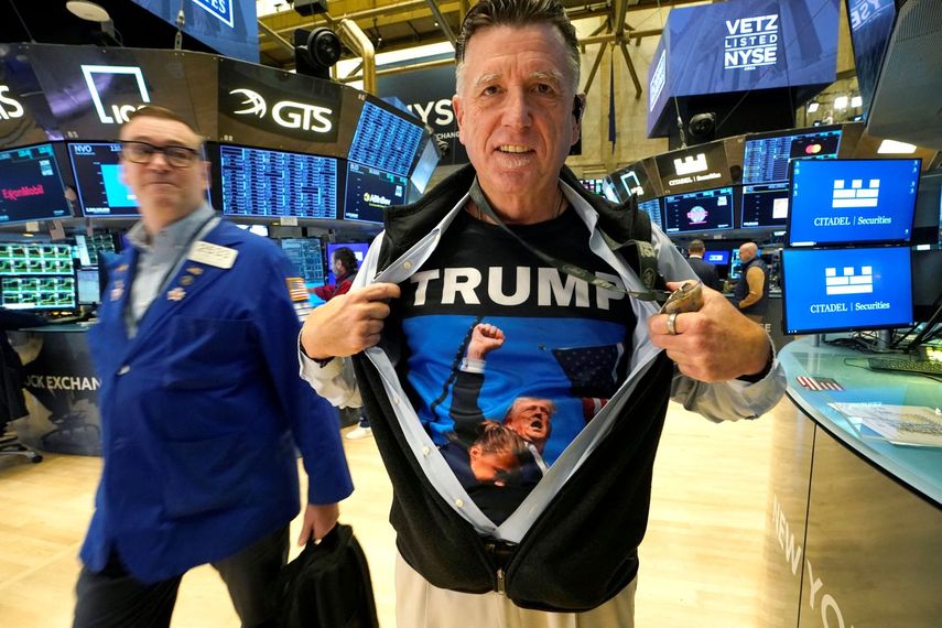 Un agente de la Bolsa de Nueva York muestra su camiseta estampada con la imagen de Donald J. Trump segundos después de sobrevivir al atentado que casi le quita la vida en Butler, Pennsylvania.