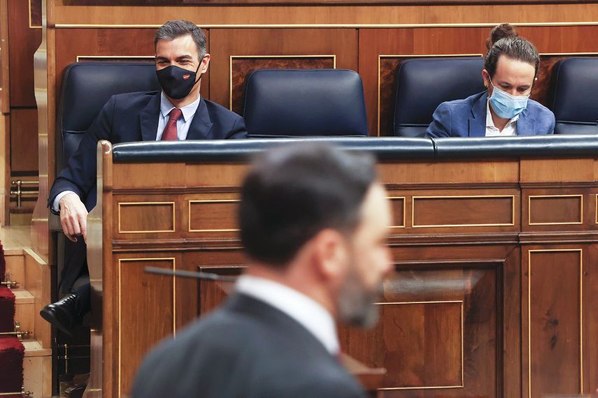El líder de VOX, Santiago Abascal, pasa frente al presidente del Gobierno de España, Pedro Sánchez (i) y el vicepresidente segundo, Pablo Iglesias (d), en el pleno del Congreso.