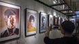Esta foto tomada el 14 de julio de 2023 muestra a un hombre tomando una foto de retratos de Bruce Lee en una exhibición de arte en Hong Kong, para conmemorar el 50 aniversario de su muerte.