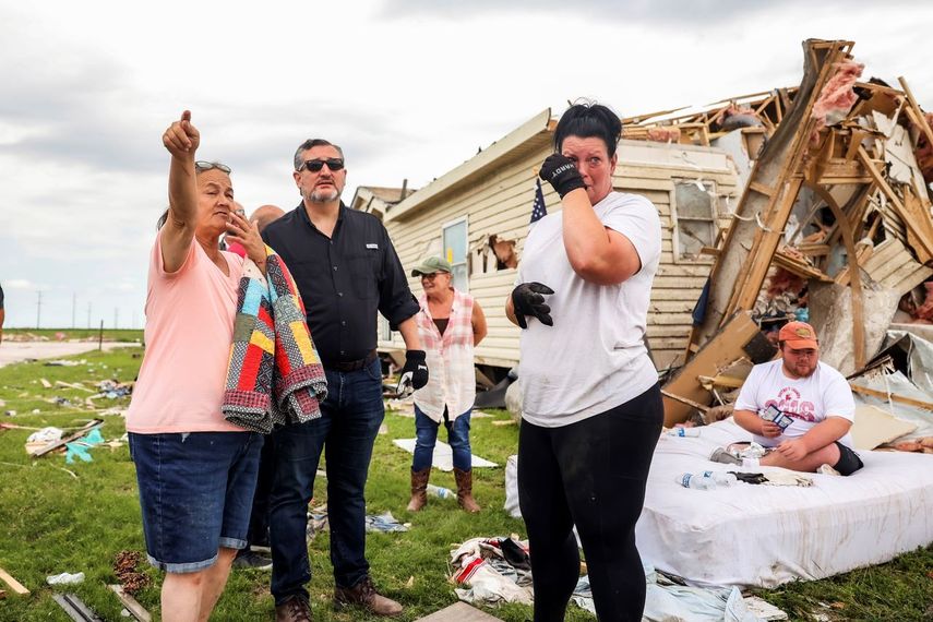 El senador Ted Cruz, derecha, camina junto a una familia mientras revisa los daños a su casa en Perryton, Texas, el sábado 17 de junio de 2023. 