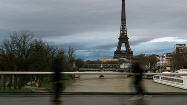 Los peatones caminan por el puente Grenelle-Cadets de Saumur con la Torre Eiffel al fondo bajo un cielo nublado en París, el 26 de enero de 2025. 