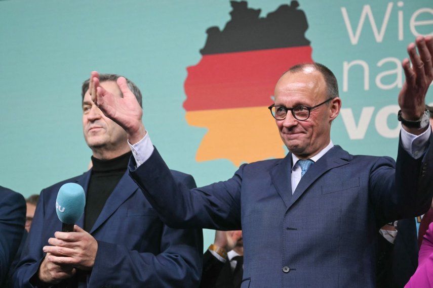 Friedrich Merz (d), líder de la conservadora Unión Cristianodemócrata (CDU) de Alemania y principal candidato de su partido a la cancillería, reacciona junto al primer ministro del estado de Baviera y líder de la conservadora Unión Social Cristiana (CSU), Markus Soeder, después de que se anunciaran en la televisión las primeras encuestas a pie de urna en las elecciones generales alemanas durante la noche electoral en Berlín el 23 de febrero de 2025.