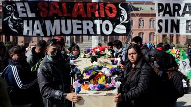Integrantes de organizaciones sociales realizan un simulacro de velorio por la muerte del salario, en referencia a los salarios que no están a la altura de la inflación, frente al palacio de gobierno Casa Rosada en Buenos Aires, el 19 de agosto de 2022.