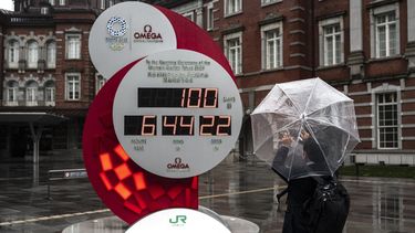 Un hombre toma una foto de un reloj de cuenta regresiva para los Juegos Olímpicos y Paralímpicos de Tokio 2020 100 días antes de la ceremonia de apertura, frente a una estación de Tokio en Tokio el 14 de abril de 2021. &nbsp; &nbsp;