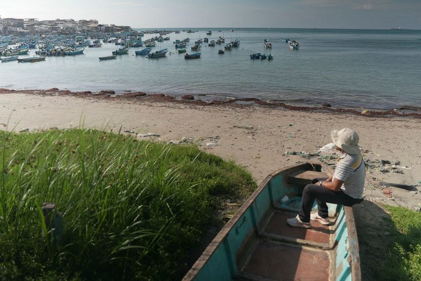 Un pescador descansa sentado en una embarcación en la playa de Salinas, un pequeño puerto pesquero en Ecuador.&nbsp;