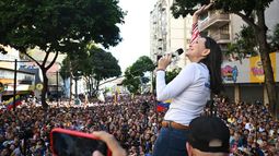 La líder de la oposición, María Corina MAchado, saluda a un avión del régimen que sobrevolaba por la manifestación opositora en Caracas