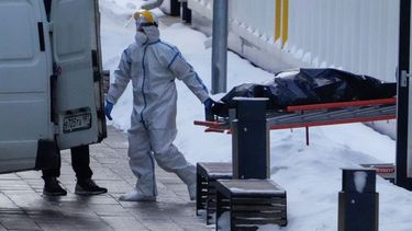 Trabajadores hospitalarios llevan un cadáver a una camioneta fuera de un hospital en Kommunarka, en las afueras de Moscú en Rusia, el 27 de enero del 2022.&nbsp;
