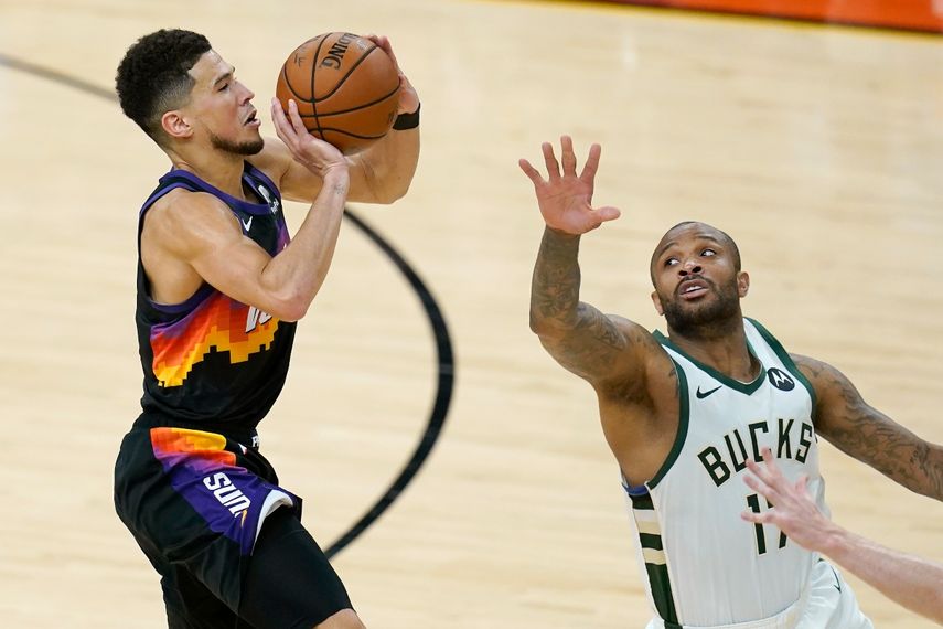 El escolta de los Suns de Phoenix, Devin Booker, dispara ante la defensiva del alero de los Bucks de Milwaukee, P.J. Tucker, en la segunda mitad del segundo juego de las Finales de la NBA
