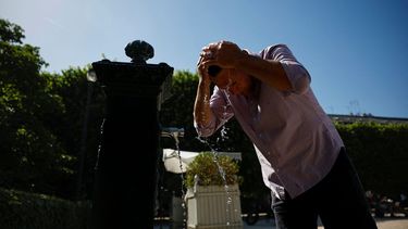 Un hombre se refresca echándose agua de una fuente en el cabello en el Jardín del Palais Royal, en el centro de París, el 26 de mayo de 2026, mientras una ola de calor azota Francia.