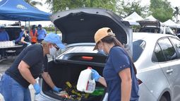 Voluntarios colocaban los alimentos en la parte trasera de los veh&iacute;culos.