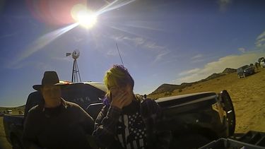 En esta captura de pantalla del video de una cámara de solapa proporcionada por la Oficina del Jefe de Policía del Condado de Santa Fe, la armera de cine Hannah Gutiérrez-Reed, a la derecha, llora al hablar con un asistente del alguacil mientras un colega está junto a ella en el set de la película de vaqueros Rust. Jueza rechaza desestimar cargos contra armera.