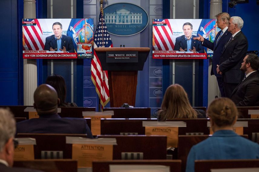 El presidente de los Estados Unidos, Donald Trump, y el vicepresidente de los Estados Unidos, Mike Pence, observan cómo se reproduce un video del gobernador de Nueva York, Andrew Cuomo, dando una conferencia de prensa en una breve presentación previa durante una conferencia de prensa del Grupo de Trabajo Coronavirus en la Casa Blanca en Washington, DC, el 19 de abril. 2020.