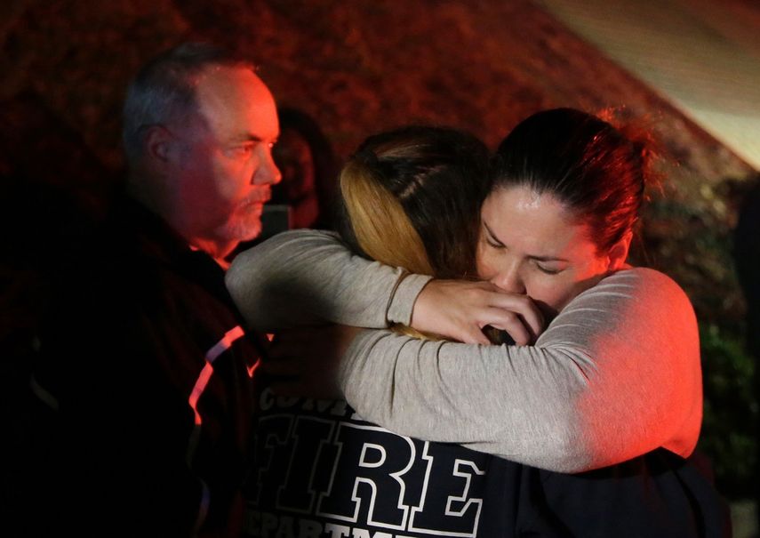 Una mujer que logró huir de los disparos en el Borderline Bar and Grill, abraza a sus familiares en la localidad de Thousand Oaks, California.