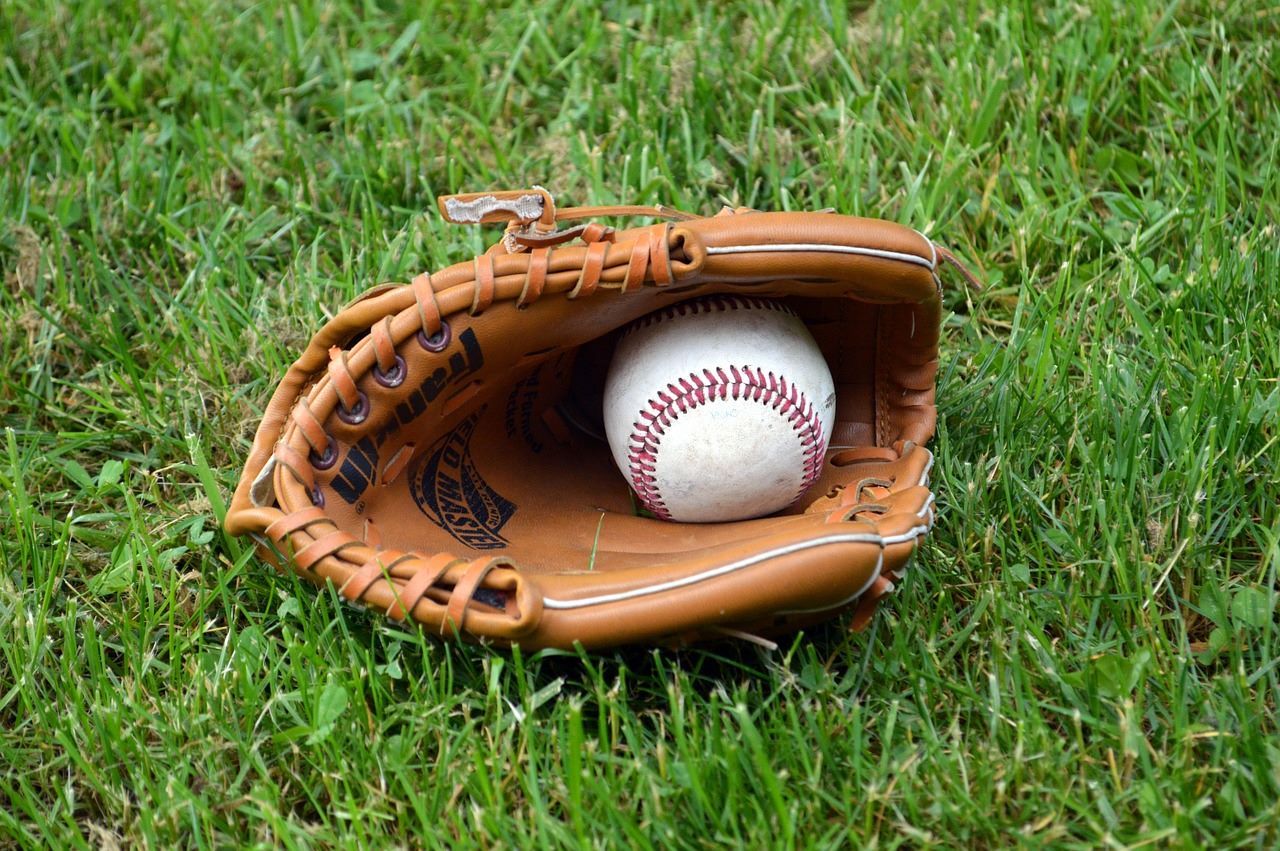 Guante y pelota en un campo de béisbol Guante y pelota en un campo de béisbol
