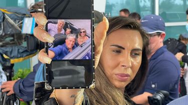 Abigail Pereira muestra fotos de familiares desaparecidos, tras derrumbe de edificio en Surfside, al norte de Miami Beach.