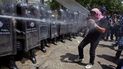Un oficial de la Policía Nacional Bolivariana rocía aerosol pimienta sobre un manifestante durante enfrentamientos registrados en la Universidad Central de Caracas. 