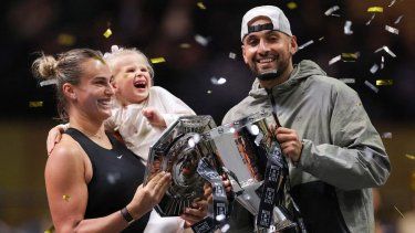Aryna Sabalenka (izquierda), su ahijada Nicole y Nick Kyrgios de Australia celebran con los trofeos al final del partido de tenis de exhibición de la Batalla de los Sexos en Dubai el 28 de diciembre de 2025.