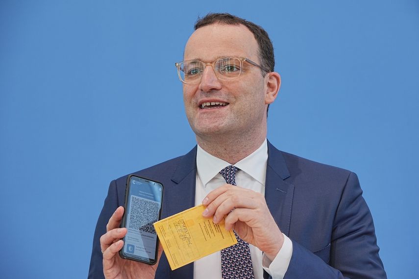 El ministro de Salud de Alemania, Jens Spahn, presenta la aplicación Corona Warn con un certificado digital de vacunación en la pantalla de su celular y su propio certificado de vacunación en la mano, durante una conferencia de prensa sobre la situación por el coronavirus, en Berlín, Alemania, el jueves 10 de junio de 2021.&nbsp;