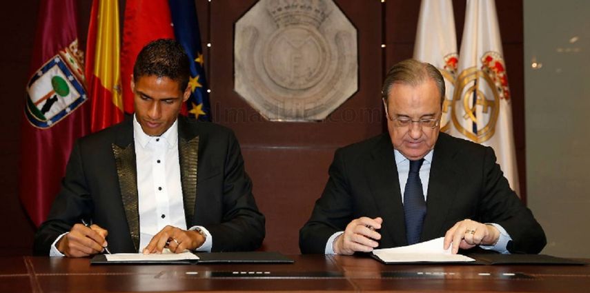 Varane (izquierda) durante la firma del acuerdo con el presidente del Real Madrid, Florentino Pérez. 