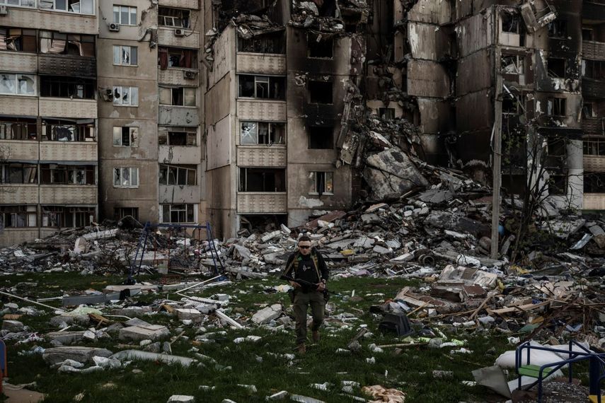 Un militar ucraniano camina entre los escombros de un edificio gravemente dañado por bombardeos rusos el lunes 25 de abril de 2022, en Járkiv, Ucrania