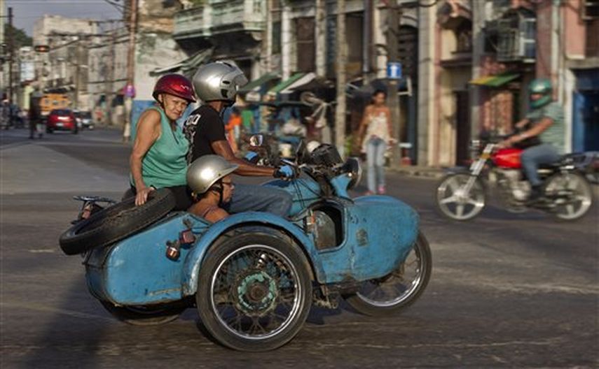 En una escena cotidiana del 8 de octubre del 2014, unos cubanos viajan en una moto soviética con sidecar en La Habana, Cuba. Foto AP /Archivo