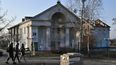 La gente pasa frente a una casa de la cultura muy dañada en Irpin, al noroeste de Kyiv, el 23 de diciembre de 2022, en medio de la invasión rusa de Ucrania. El edificio de la biblioteca salió prácticamente indemne de los intensos combates de la guerra.