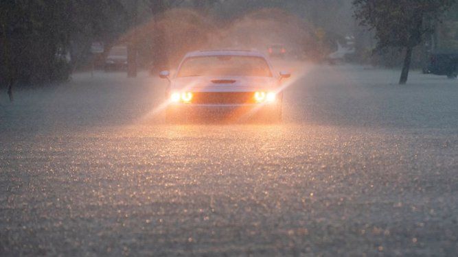 Un conductor parpadea sus luces de emergencia mientras cae una fuerte lluvia sobre partes del sur de Florida el miércoles 12 de junio de 2024, en Hollywood, Florida.