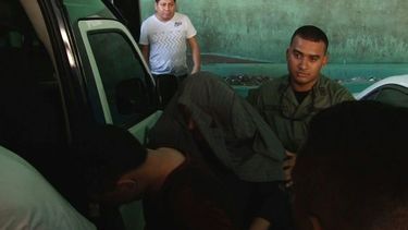 Momento en que Ramón Martinelli Corro salía de la Audiencia, cubierto su rostro.