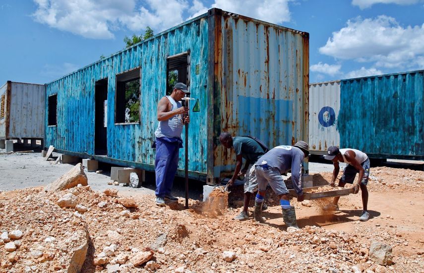 Personas construyen una vivienda en un contenedor de metal en La Habana, Cuba, ante el enorme déficit de casas.