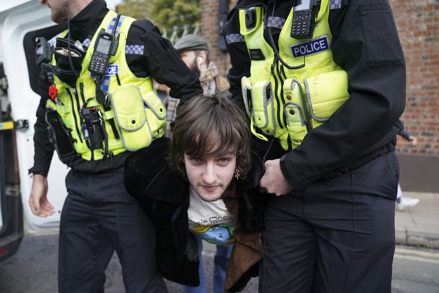 La policía detiene a un manifestante que pareció arrojar huecos al rey Carlos III y a la reina consorte cuando llegaron al Micklegate Bar, donde se recibe tradicionalmente al soberano en la ciudad de York, Inglaterra, el miércoles 9 de noviembre de 2022.