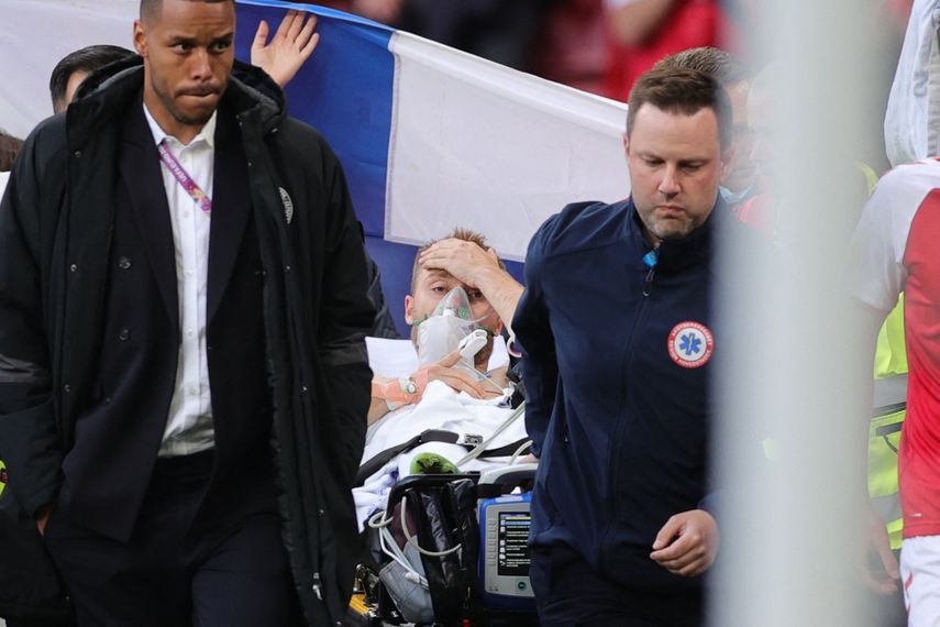 El futbolista danés Christian Eriksen (C) es evacuado después de colapsar en el campo durante el partido de fútbol del Grupo B de la UEFA EURO 2020 entre Dinamarca y Finlandia en el Estadio Parken de Copenhague el 12 de junio de 2021
