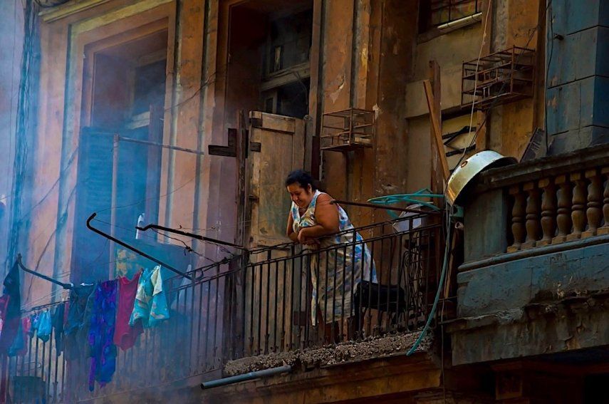 Una mujer asomada a un balcón en La Habana Vieja, Cuba.&nbsp;