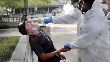 Personal sanitario le realiza la prueba de coronavirus a un desamparado en Miami.