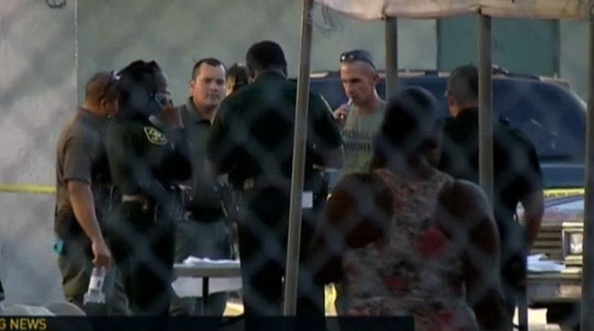 Los detectives de la Policía de Broward inspeccionan el área del suceso.