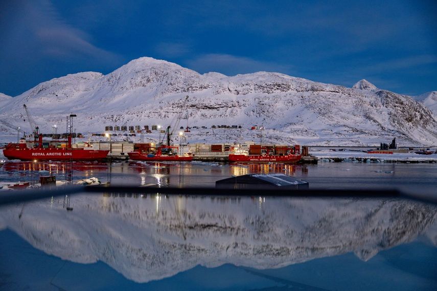 El puerto y la montaña detrás se reflejan en una ventana en Nuuk, Groenlandia.