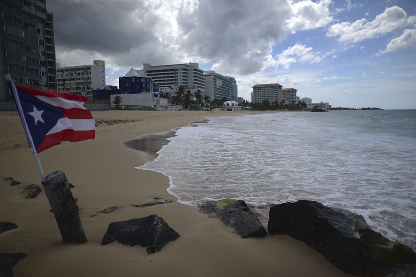 Una bandera de Puerto Rico ondea en una playa vacía en Ocean Park, el jueves 21 de mayo de 2020, en San Juan.&nbsp;