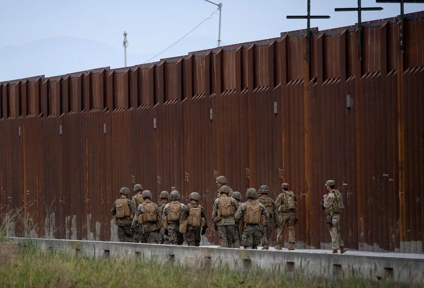 Militares estadounidenses caminan junto al muro fronterizo entre Estados Unidos y México.