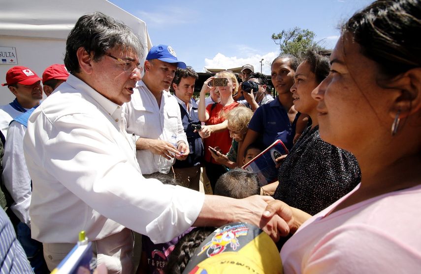 El canciller colombiano Carlos Holmes Trujillo conversa con venezolanos que buscan cruzar el paso fronterizo de la ciudad de Cúcuta, en la frontera con Venezuela.