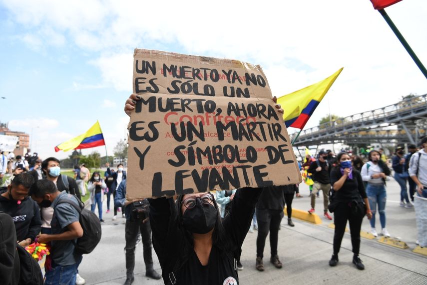 Una mujer sostiene un cartel que dice Un muerto ya no es solo un muerto, ahora es un mártir y un símbolo de levantamiento durante una manifestación contra la reforma tributaria propuesta por el presidente colombiano Iván Duque, en Bogotá, Colombia, en abril. 28 de 2021