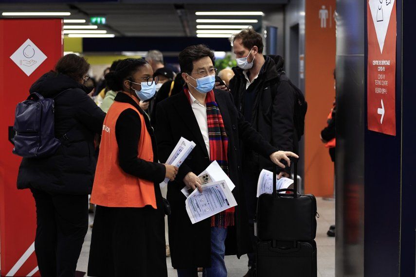 Pasajeros procedentes de China aguardan frente a una zona de pruebas de COVID-19 en el aeropuerto Roissy Charles de Gaulle, al norte de París, el domingo 1 de enero de 2023.&nbsp;