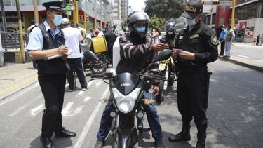 Un migrante venezolano muestra su documentación durante un control de seguridad en el distrito de Miraflores, en Lima, Perú.