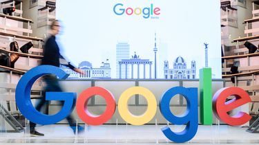 Un empleado camina junto al logotipo de la multinacional estadounidense Google. 