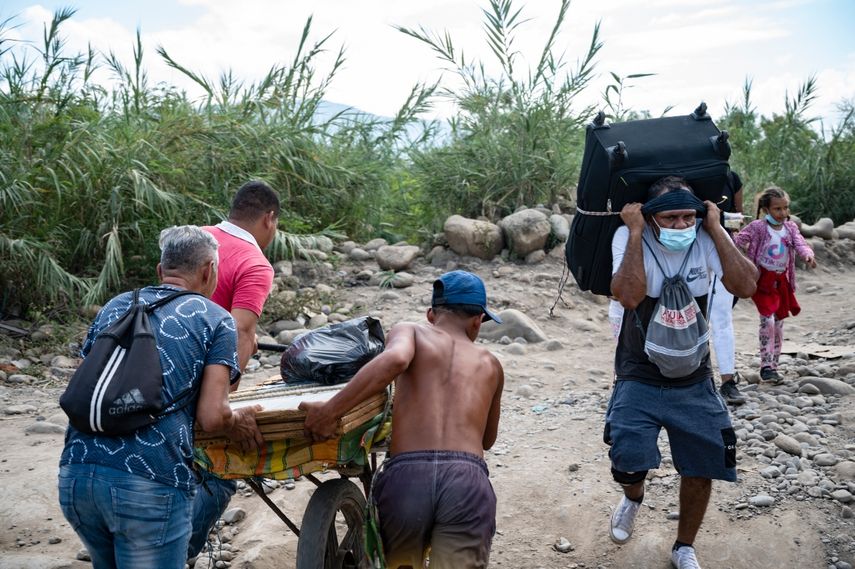 Venezolanos empujan un carro cargado de compras hacia Venezuela a través de las llamadas trochas - senderos ilegales- en Cúcuta, los cuales también siempre han estado minados por el contrabando.