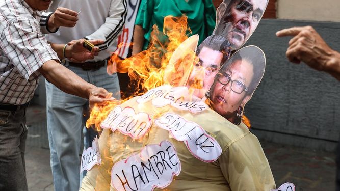 Un grupo de personas quema un muñeco con la foto de la cara de Nicolás Maduro; del ministro de Comunicación, Jorge Rodriguez; del ministro de Defensa, Vladimir Padrino y la alcaldesa de Caracas, Érika Faría.&nbsp;