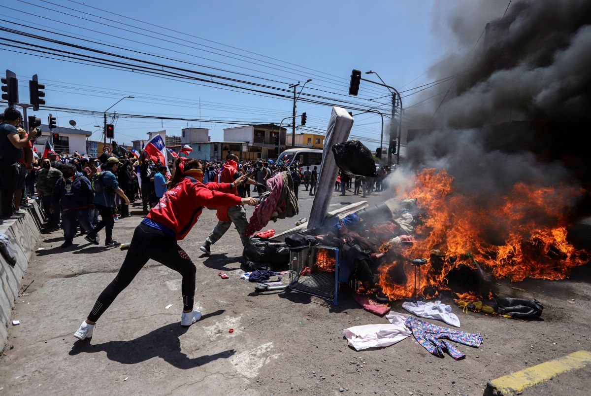 Residentes queman carpas y artículos pertenecientes a migrantes venezolanos y colombianos durante una marcha contra la migración irregular, en Iquique, Chile, el sábado 25 de septiembre de 2021. Residentes queman carpas y artículos pertenecientes a migrantes venezolanos y colombianos durante una marcha contra la migración irregular, en Iquique, Chile, el sábado 25 de septiembre de 2021.